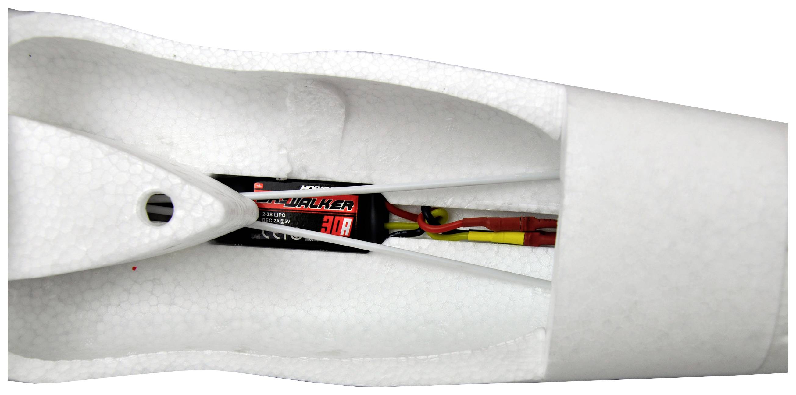 Innenseite eines Modellflugzeugrumpfs aus weißem Schaumstoff. Eine elektronische Komponente mit Kabeln ist eingebaut.