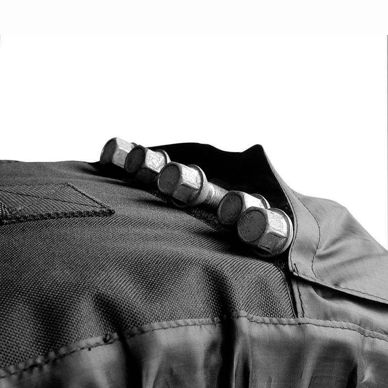 Jacke mit aufgenähten Knöpfen in einer Reihe, schwarz-weiß, Fokus auf die Textur des Stoffes und das Design der Knöpfe.