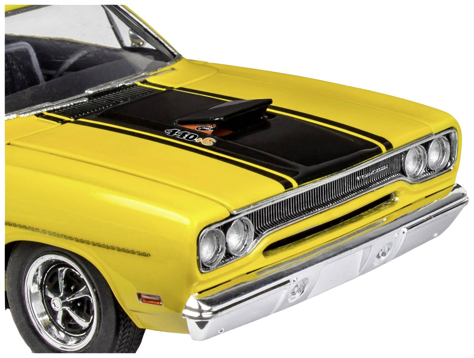 Gelber Oldtimer-Wagen mit schwarzer Motorhaube und auffälligem Lufteinlass. Vorderansicht mit chromglänzendem Stoßfänger.