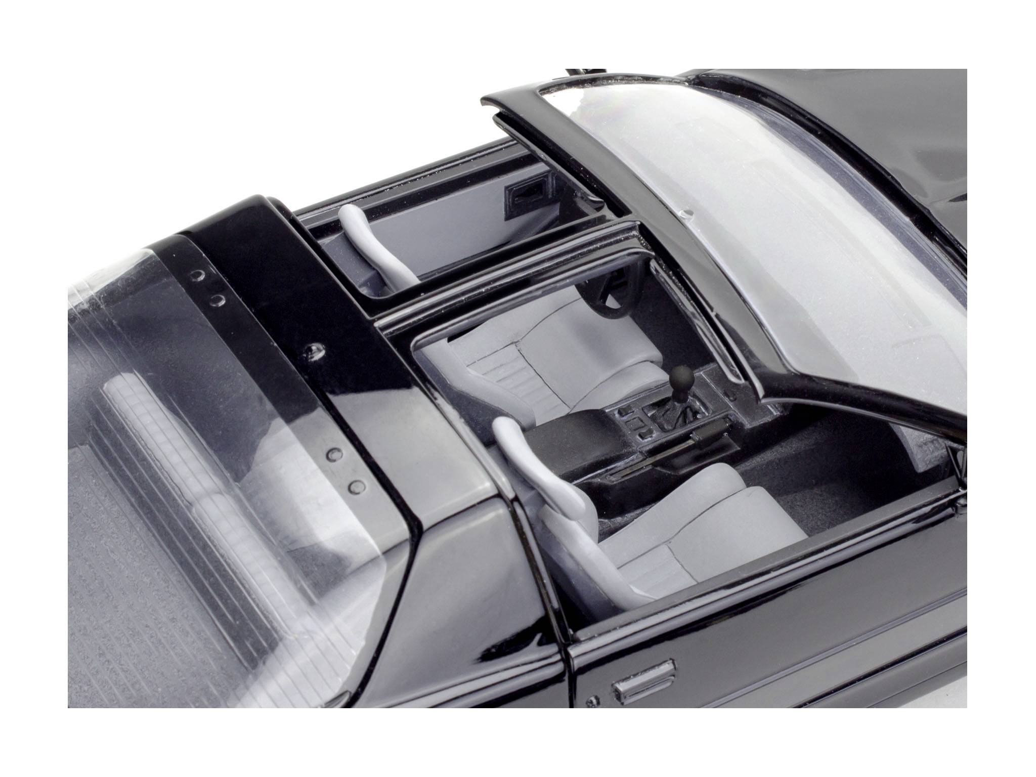 Schwarzes Auto-Modell mit offenem Schiebedach, Sicht auf graue Ledersitze und Armaturenbrett, von oben betrachtet.