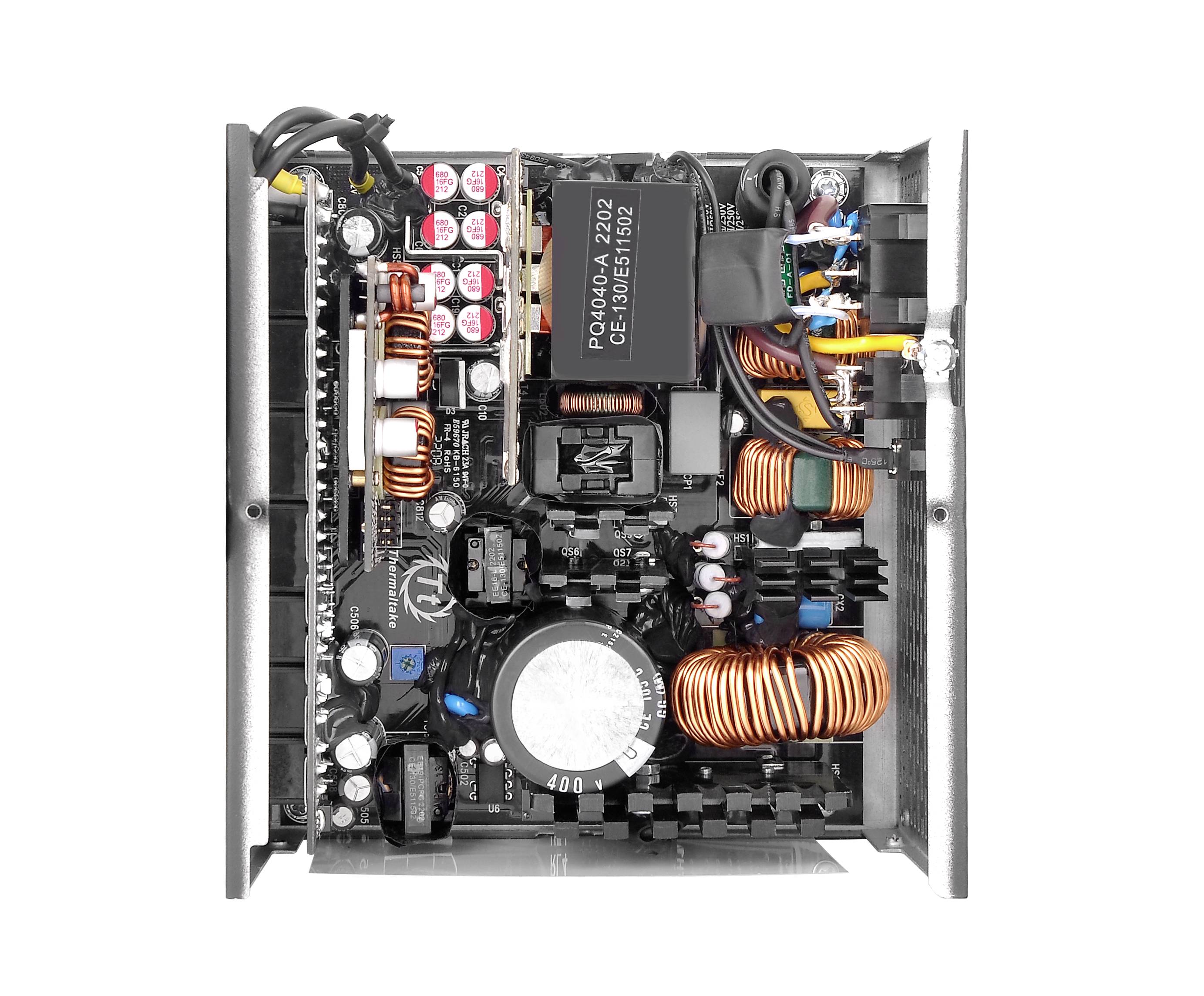 Netzteil im Inneren eines Computers, zeigt verschiedene elektronischen Komponenten wie Kondensatoren, Spulen und Kabel.