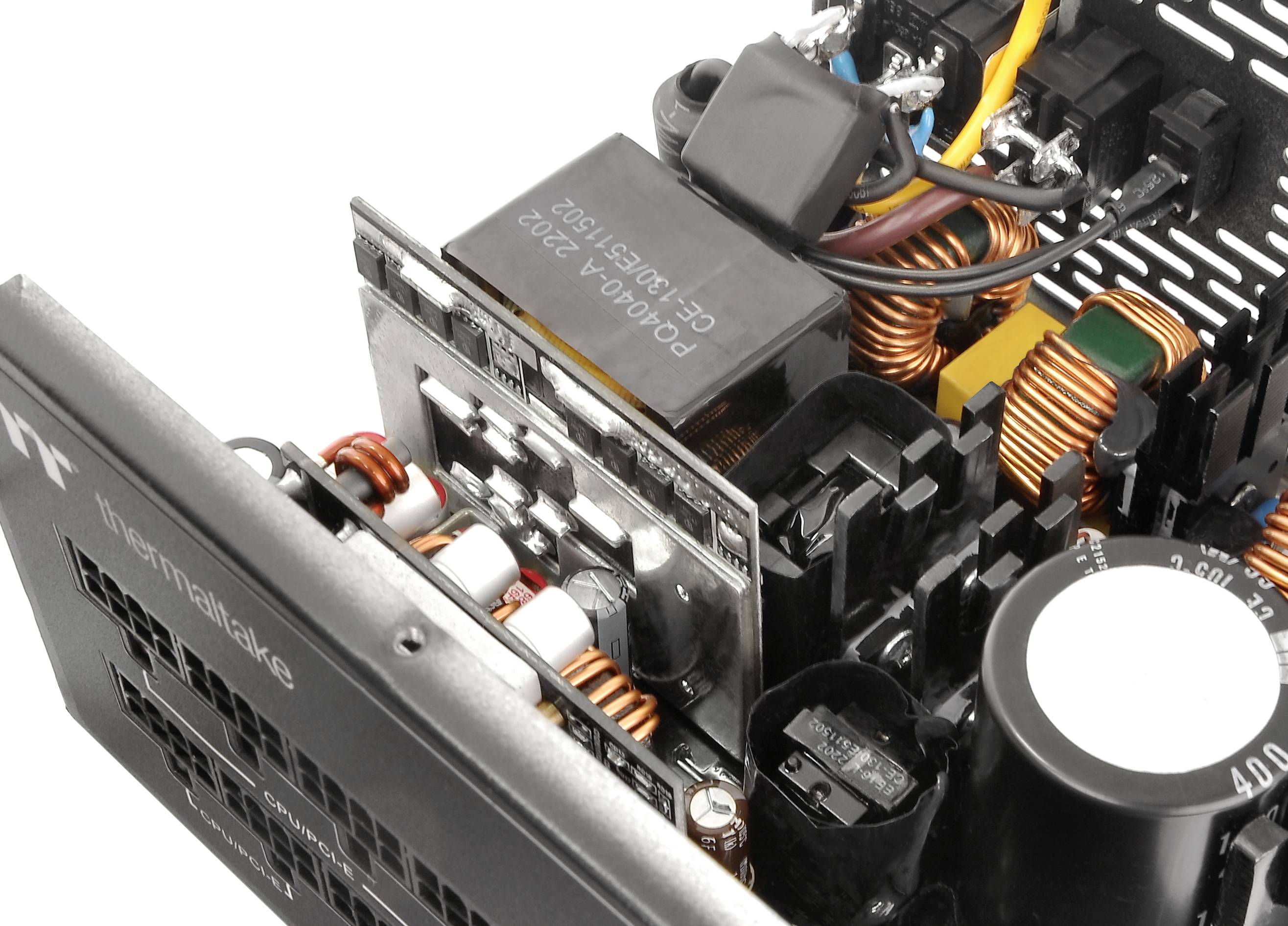 Ein geöffneter Computer-Netzteil zeigt Spulen, Kondensatoren und Kabelverbindungen. Sichtbare Beschriftung: 'InnoSwitch'.