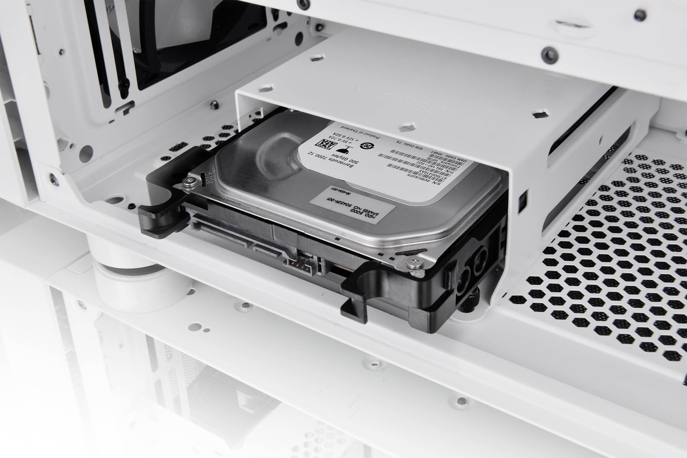 Eine Festplatte ist in einem offenen weißen Computergehäuse eingebaut, das einen Blick auf die interne Hardware ermöglicht.