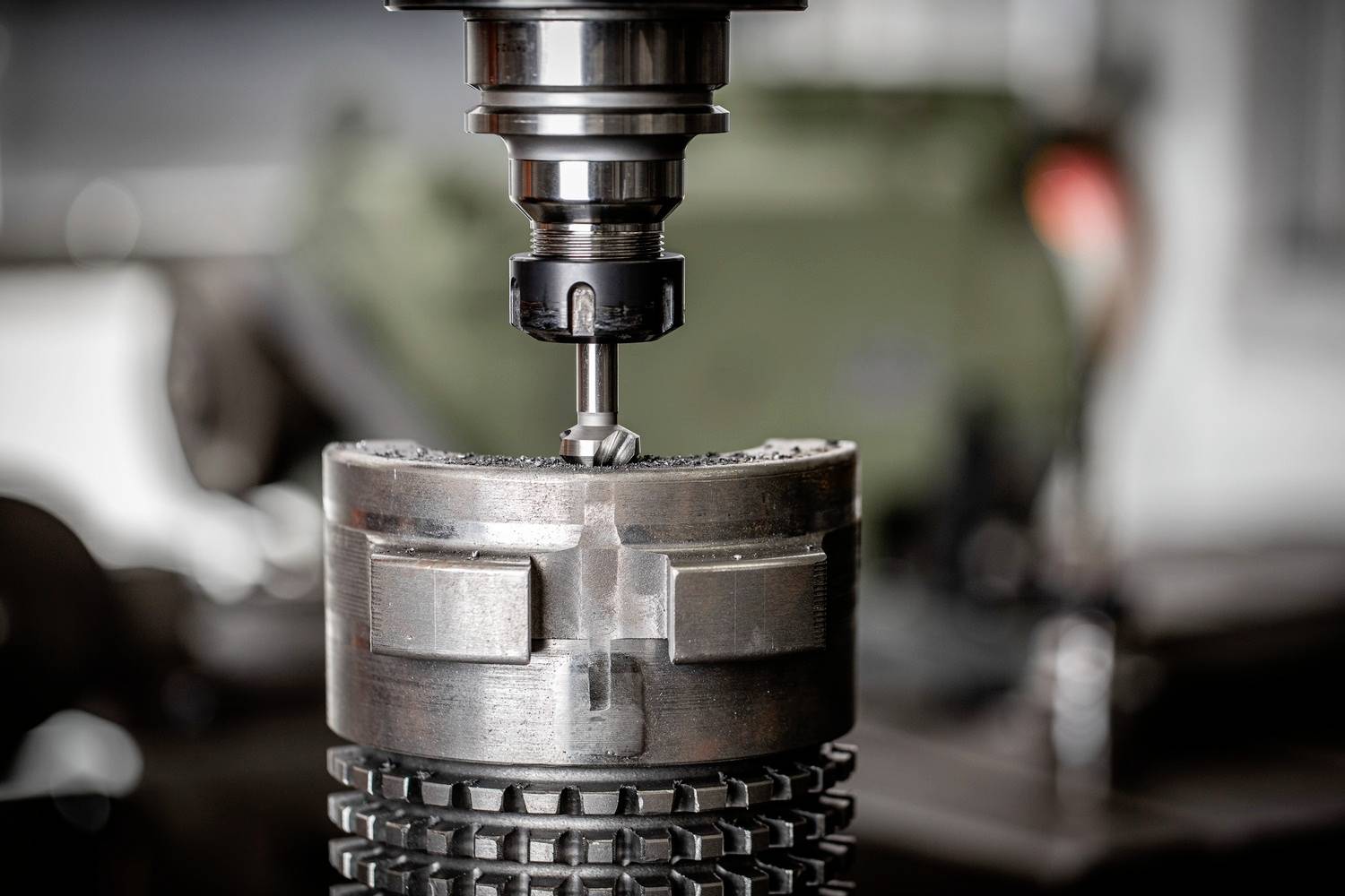 Nahaufnahme einer Fräsmaschine in Aktion, die präzise Metallbearbeitung durchführt. Hintergrund unscharf mit Werkstattausstattung.