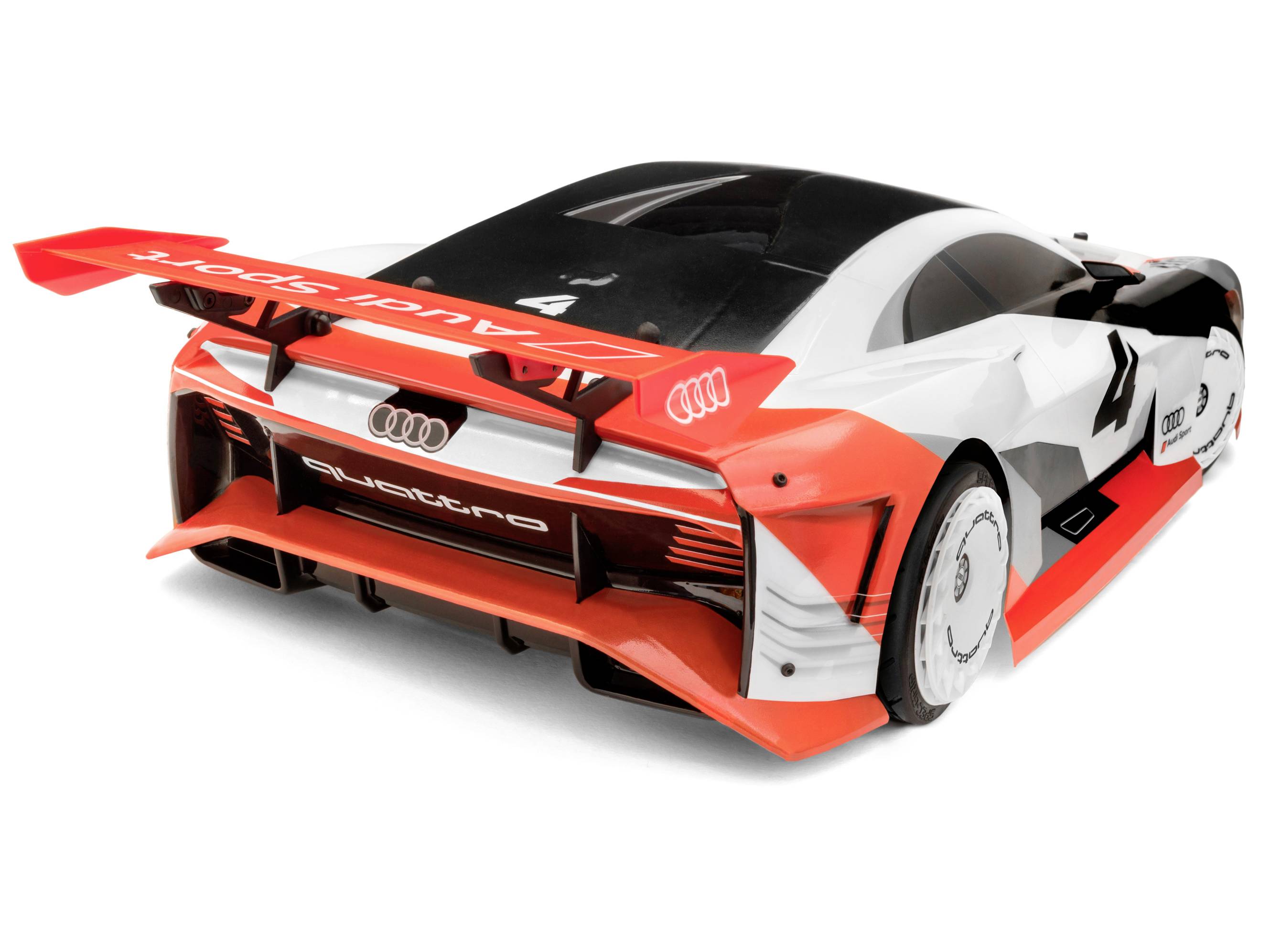 Ein weiß-rotes Spielzeugauto mit Audi-Logo, im Rennwagenstil. Das Design ist aerodynamisch mit einem großen Heckspoiler.