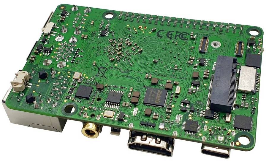 Grüne Leiterplatte mit verschiedenen elektronischen Bauteilen, inklusive USB-Anschlüssen und HDMI-Ports. Markierungen für 'CE' und 'FC'.