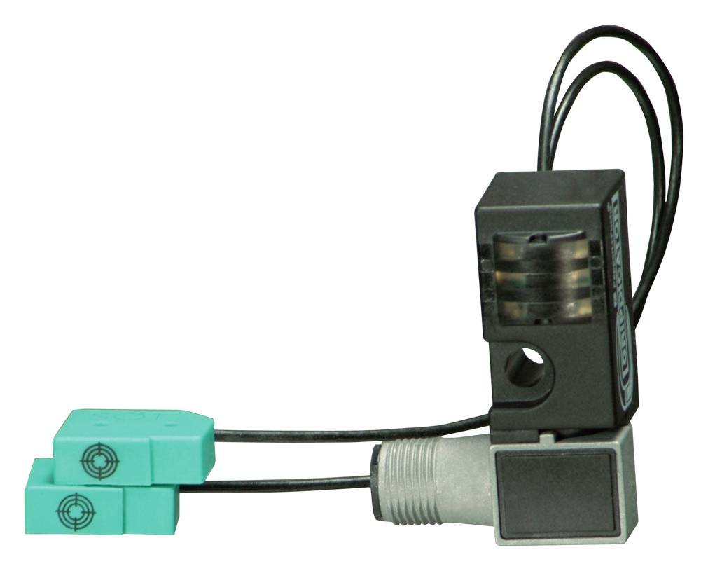 Ein Sensor mit zwei grünen Kabeln und schwarzen Verbindungen. Verwendet für industrielle Anwendungen zur Erfassung von Objekten.