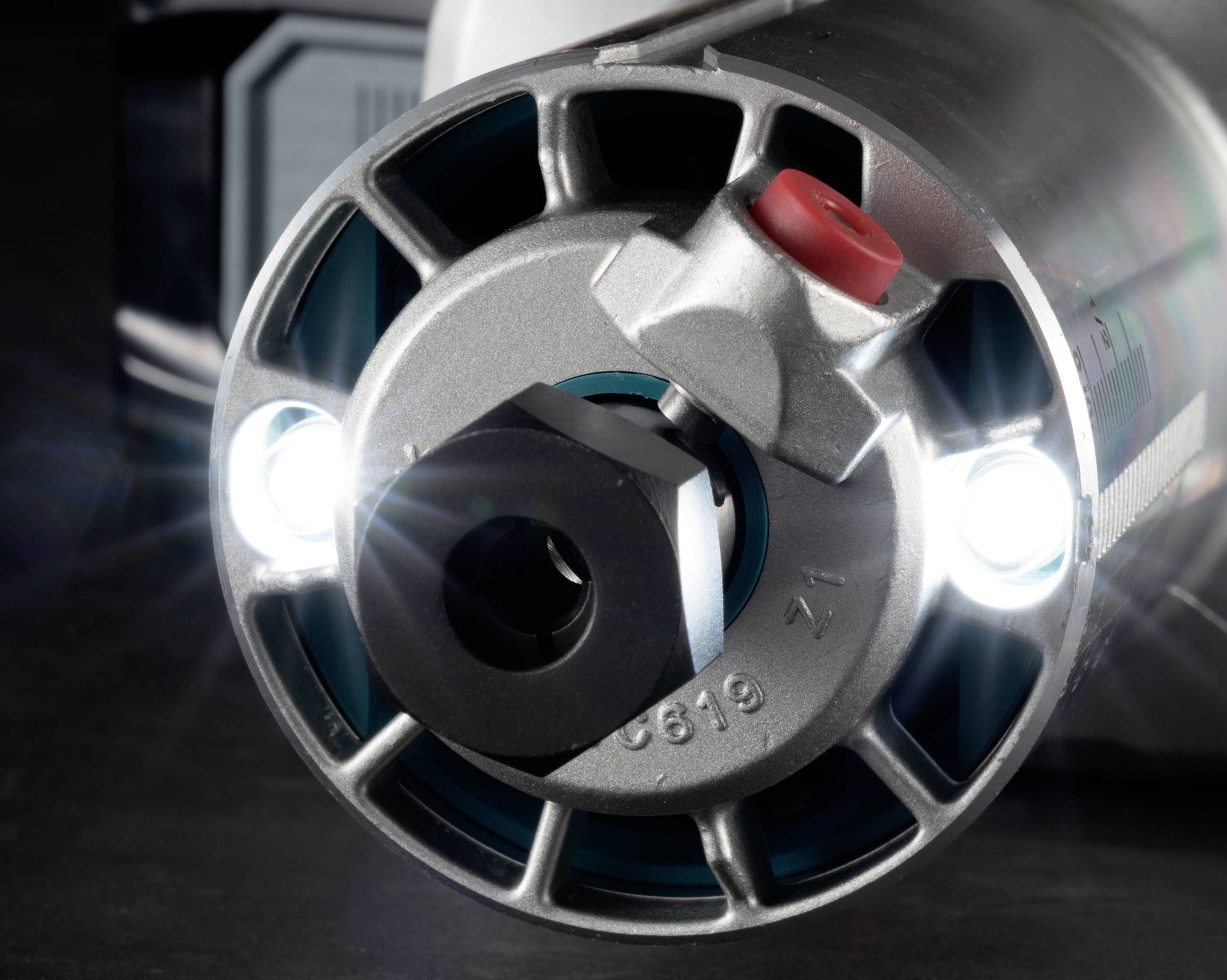 Nahaufnahme eines Elektrowerkzeug-Rotors mit beleuchteten LEDs und einem roten Schalter; zeigt technische Details und Funktionalität.