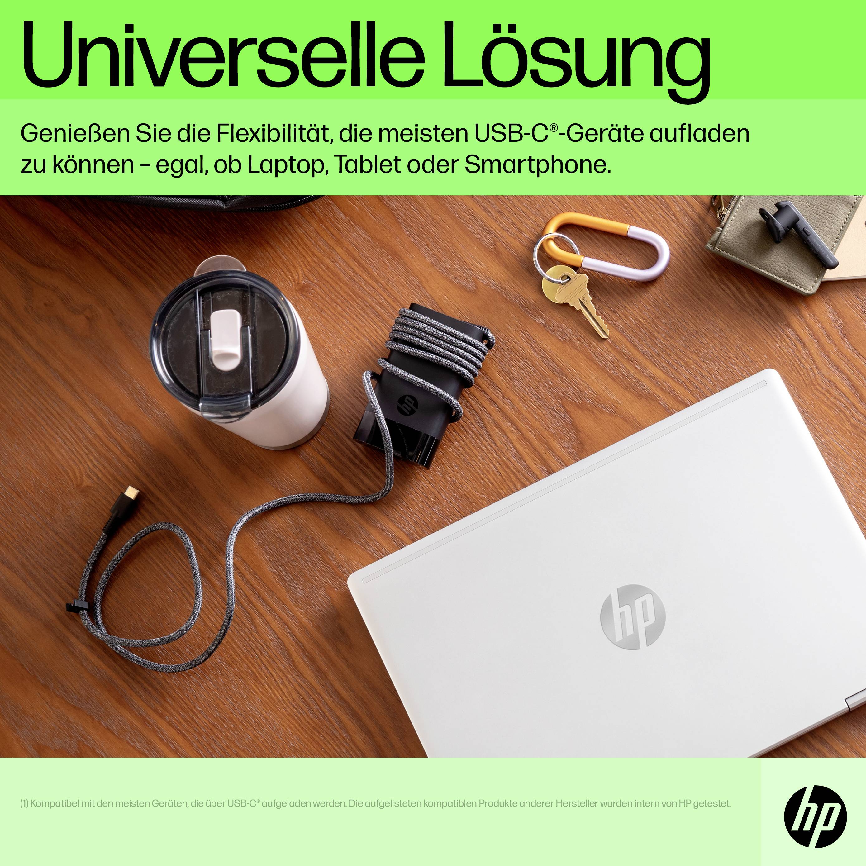 Laptop auf Tisch, umgeben von Schlüssel, Trinkflasche und Kabel. Überschrift 'Universelle Lösung', bewirbt USB-C-Aufladung.