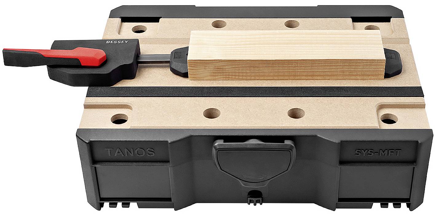 Holzstück auf Werkstückhalterung mit Klemme gesichert auf einem schwarzen und marmorierten Untergrund.
