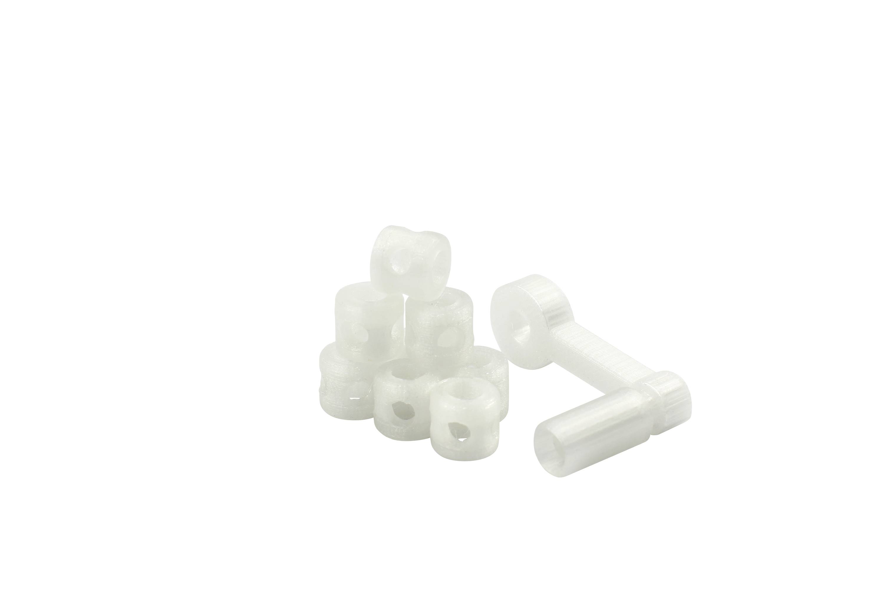 Weiße Kunststoffdistanzhalter und Schrauben auf weißem Hintergrund.