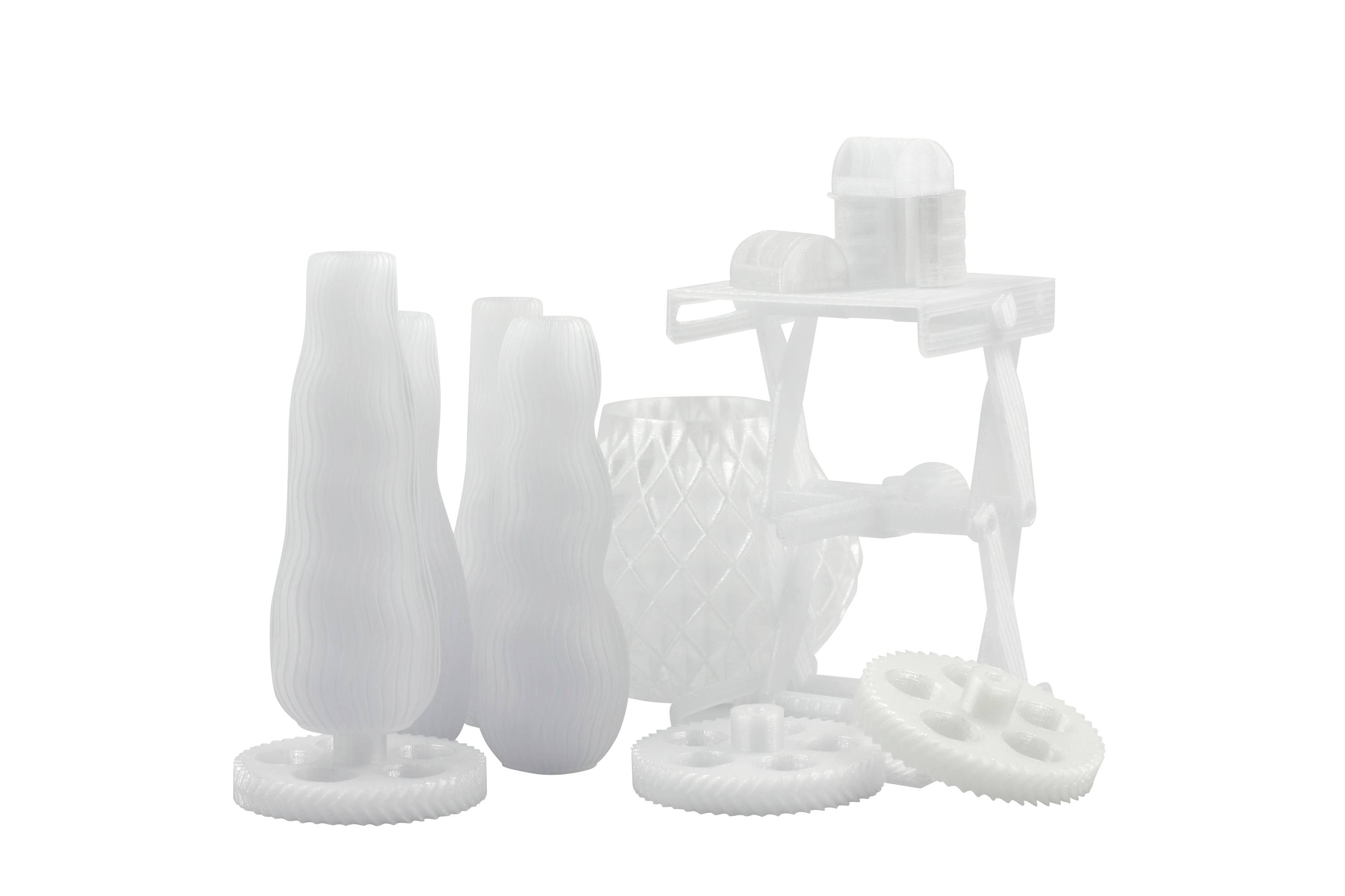 Weiße 3D-gedruckte Modelle in verschiedenen geometrischen Formen, darunter Zahnräder und Vasen, stehen auf einer weißen Oberfläche.