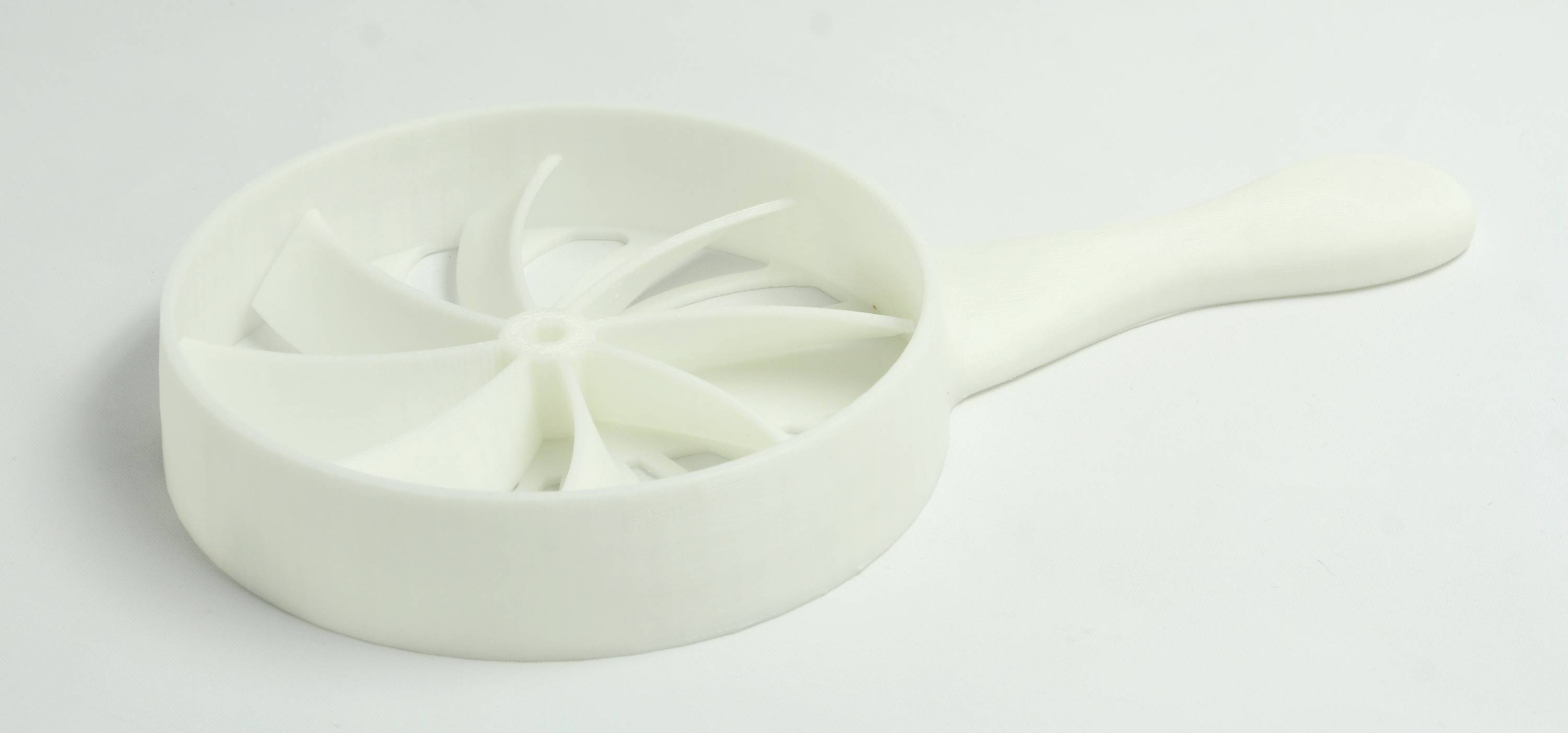3D-gedruckte, weiße Handturbine mit sechs Flügeln. Sie erinnert an einen Ventilator und hat einen runden Rahmen und einen Griff.