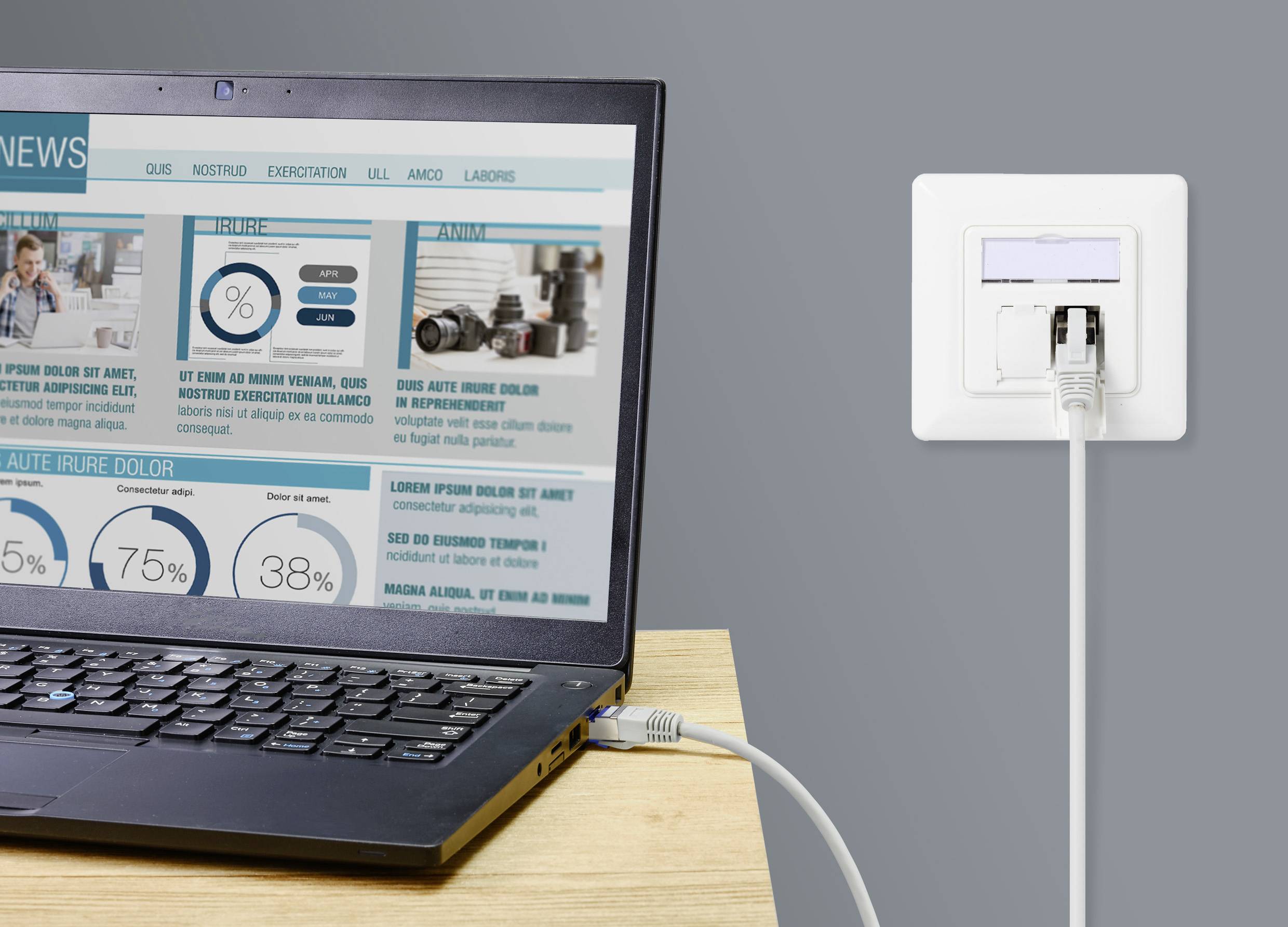 Ein Laptop auf einem Tisch ist mit einem Ethernet-Kabel an eine Netzwerksteckdose angeschlossen. Auf dem Bildschirm sind Nachrichten und Diagramme zu sehen.