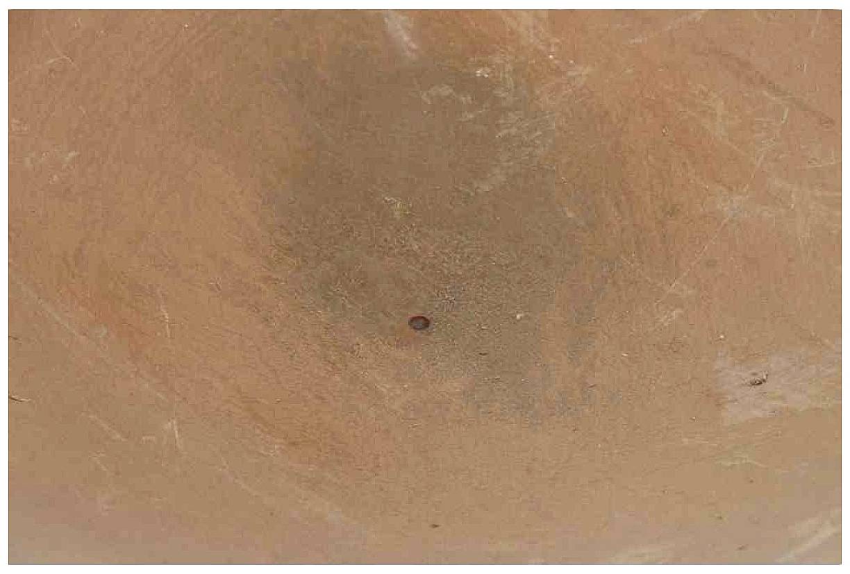 Ton-Skulptur mit erdigen Farbtönen und einer vertieften Mitte; die Textur wirkt rau und handgeformt.