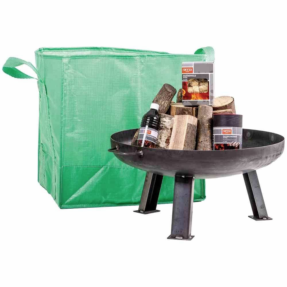 Metall-Feuerschale mit Holzscheiten, Feueranzünder und grüne Tragetasche. Bereit für Lagerfeuer oder Outdoor-Verwendung.