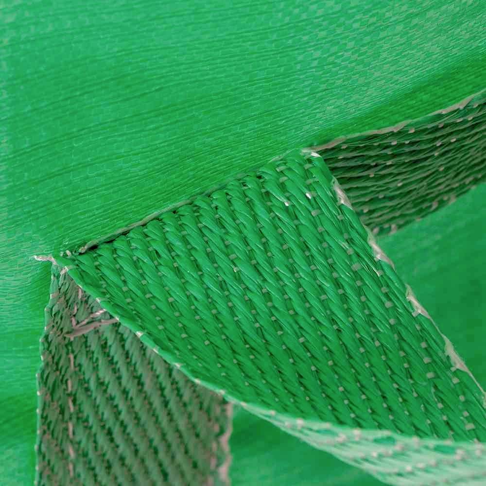 Nahaufnahme eines geflochtenen grünen Kunststoffgewebes, das Textur und Farbe des Materials zeigt.