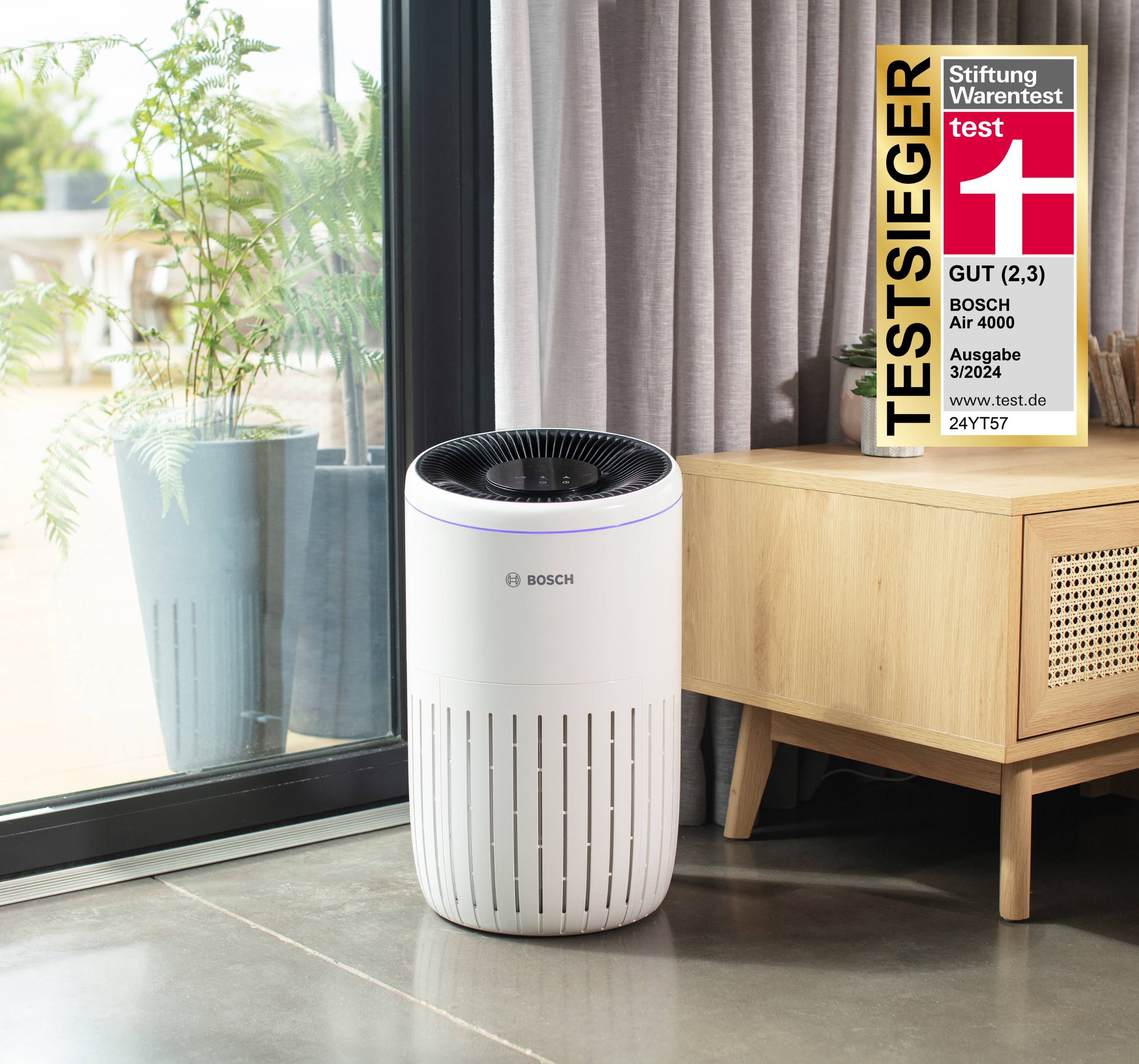 Bosch Luftreiniger neben einem Fenster und einem Schrank, mit einem „TESTSIEGER