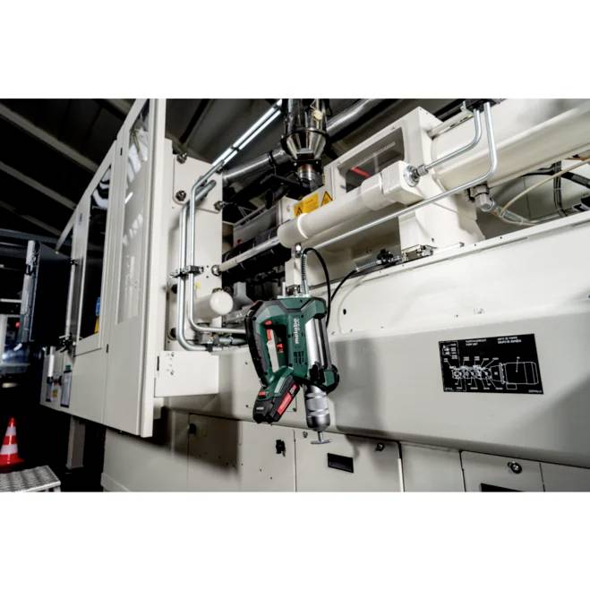 Industrielle Maschinen in einer Fabrikumgebung, die Komponenten und Rohrleitungen zeigt und einen Fokus auf Herstellungs- oder mechanische Prozesse anzeigt.