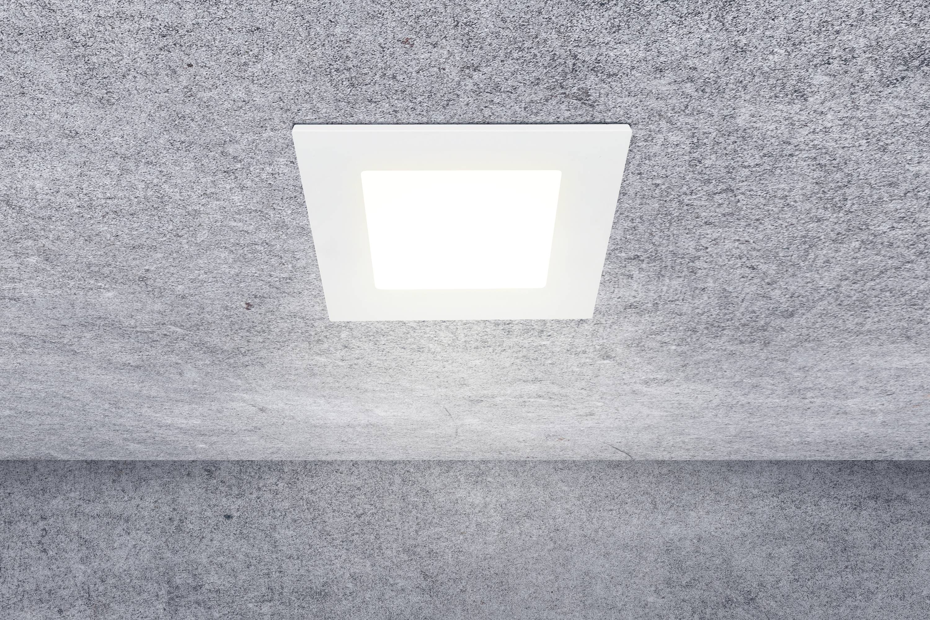 Eine quadratische Deckenleuchte strahlt helles Licht in einem Raum mit grauer Decke.