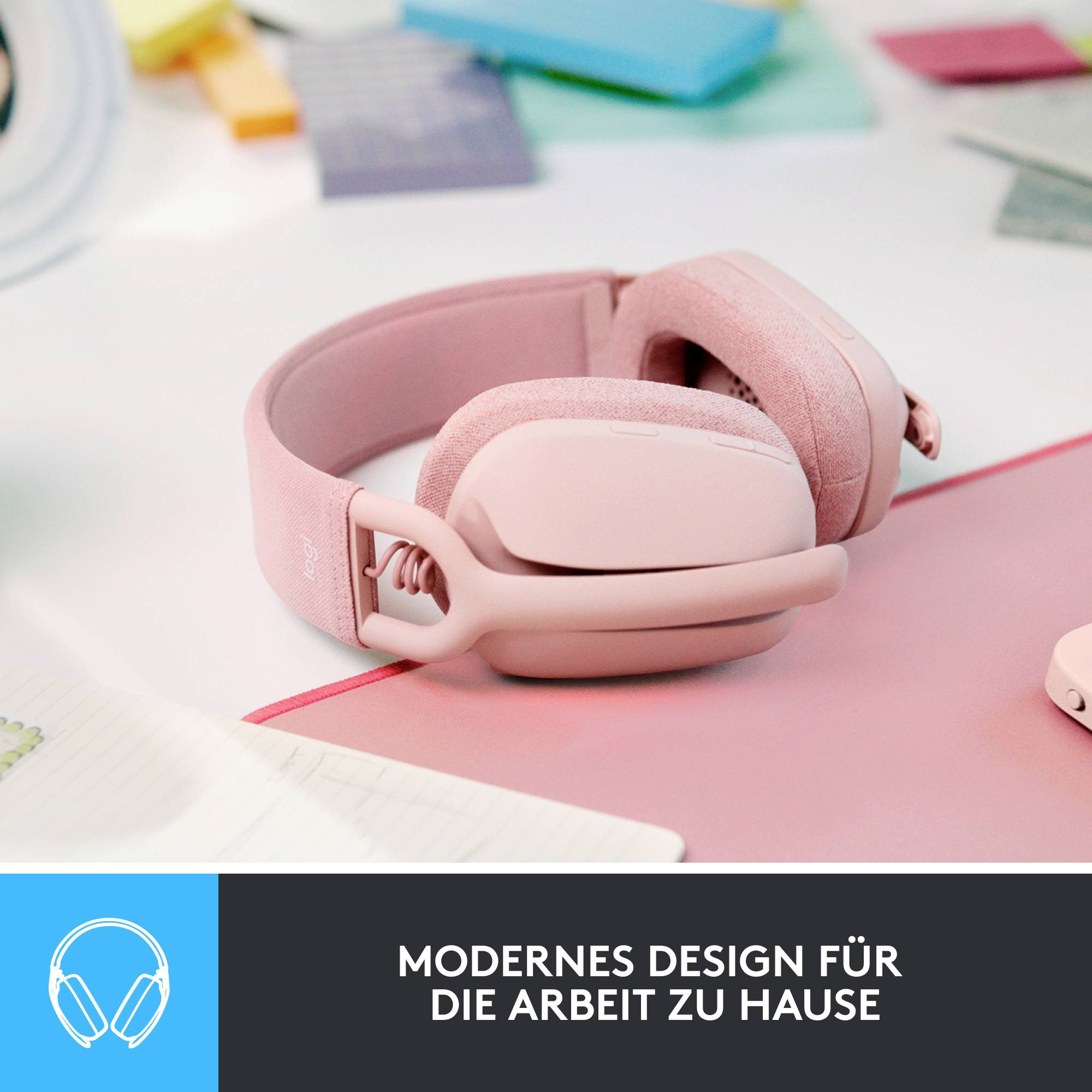 Rosa Kopfhörer auf einem Tisch, Titel darunter: 'Modernes Design für die Arbeit zu Hause'. Im Hintergrund sind bunte Notizbücher.