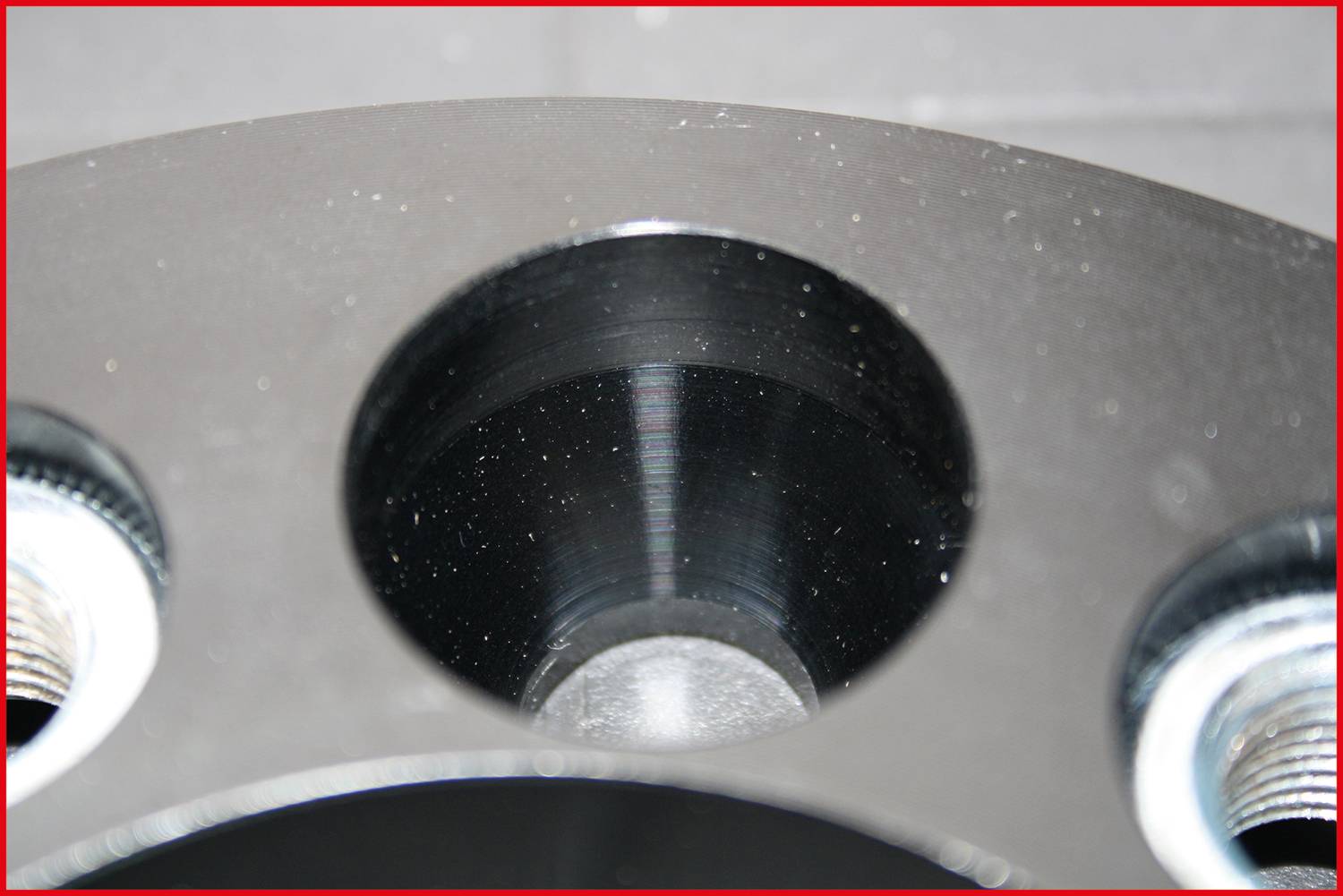 Nahaufnahme eines metallischen Bauteils mit mehreren runden Löchern, vermutlich Teil einer mechanischen oder technischen Vorrichtung.