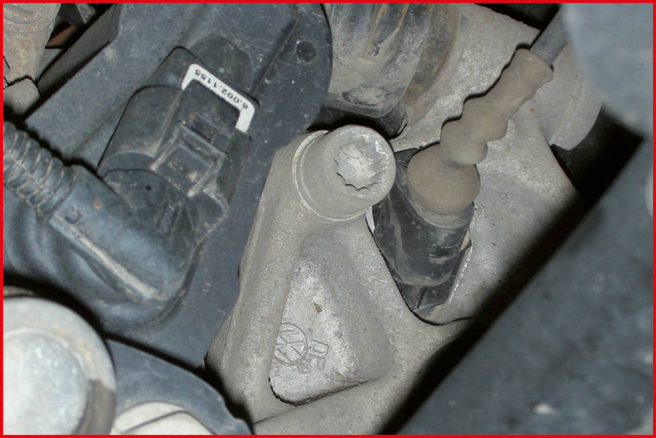 Ein Motorblock mit deutlichen Verschmutzungen und Ablagerungen; schwarze Kabel und Rohrverbindungen sind sichtbar.