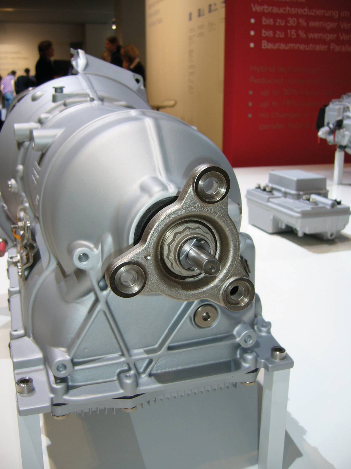 Getriebe ausgestellt in einem Museum mit Fokus auf die mechanischen Teile; im Hintergrund sind technische Details an einer Wand sichtbar.