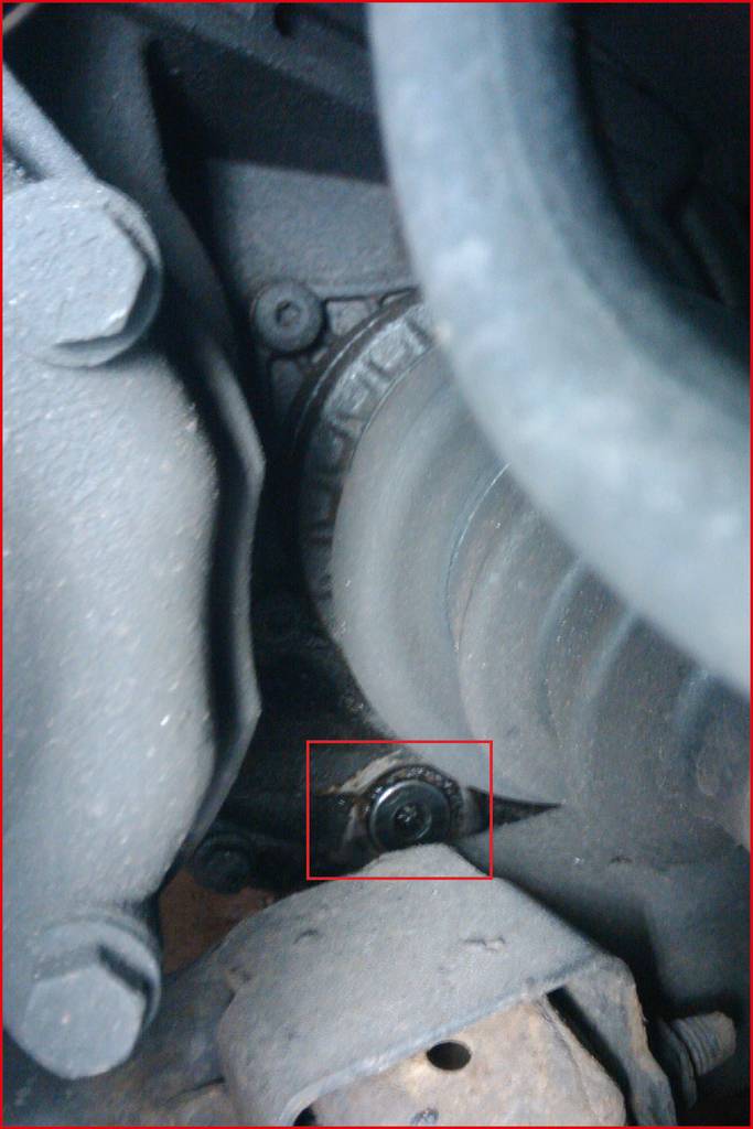 Nahaufnahme eines Autoteils, das Bolzen und eine Achse zeigt. Der Fokus liegt auf dem technischen Detail eines Fahrzeugmechanismus.