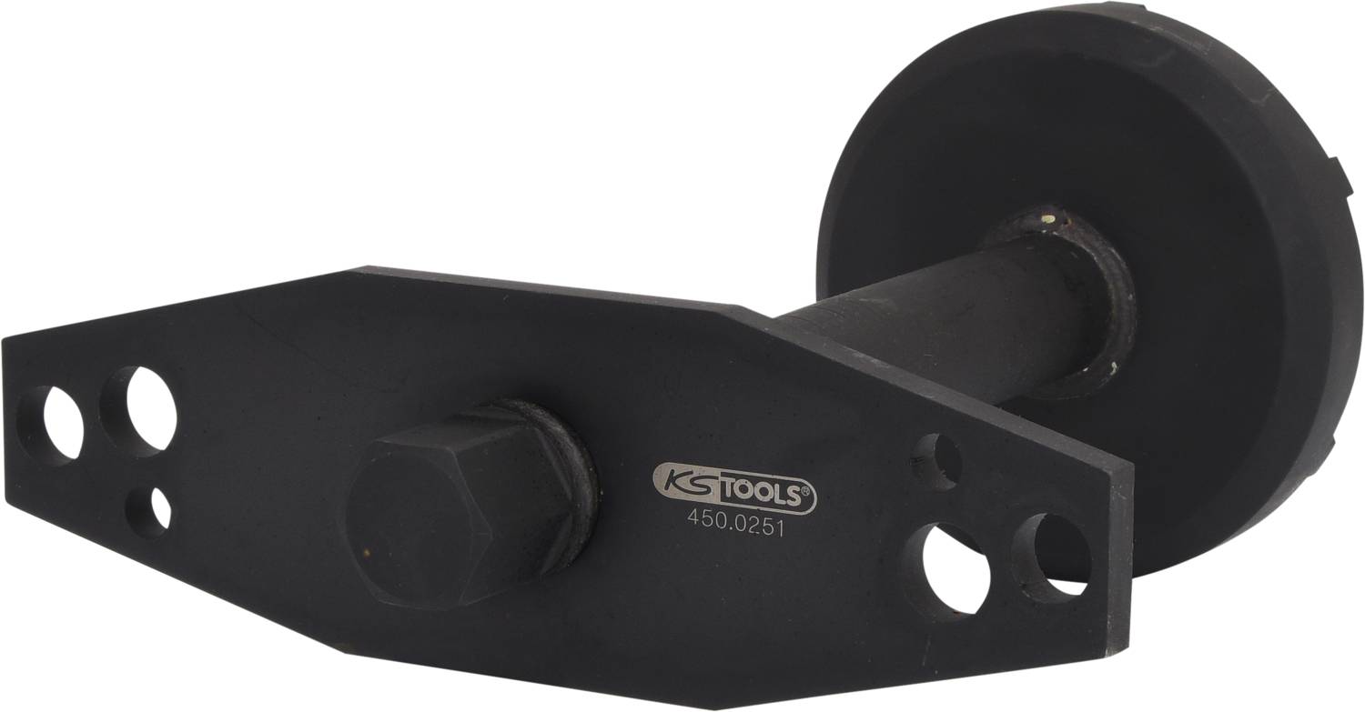 Schwarzes Werkzeugteil von KS Tools, zylindrische Form mit Sechskantmutter in der Mitte und mehreren Löchern zur Befestigung.