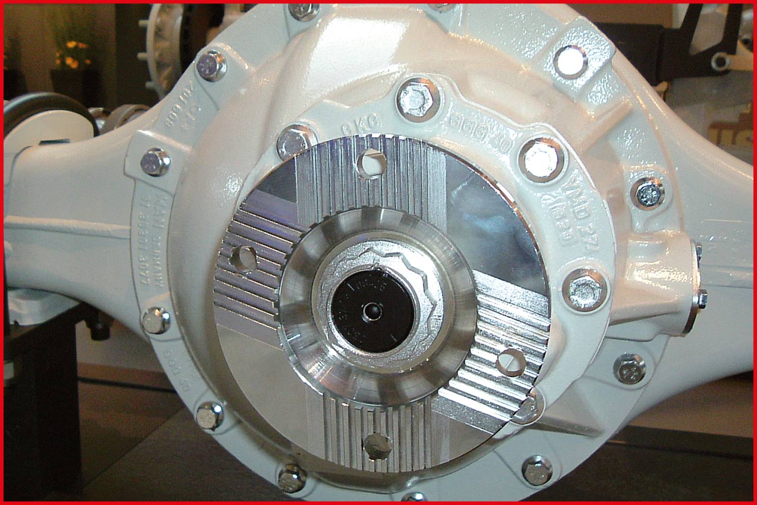 Nahaufnahme eines mechanischen Teils mit sichtbaren Schrauben und Metallkomponenten; vermutlich Teil eines Fahrzeugdifferentials.