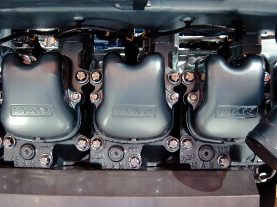 Drei Motorzylinder in einer Maschinenanordnung, gekennzeichnet mit dem Markennamen. Sichtbare Schrauben und mechanische Details.