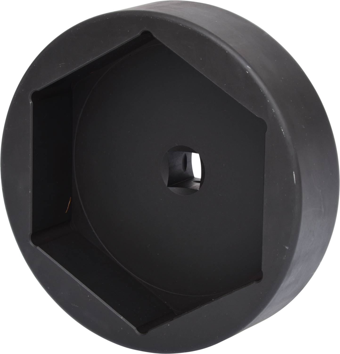 Schwarze, sechseckige Kunststoffabdeckung mit zentralem Loch, vermutlich für Schutz oder Befestigung.