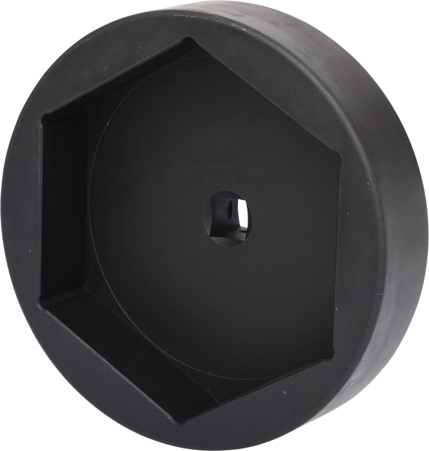 Eine schwarze, sechseckige Plastikabdeckung mit einer zentralen Öffnung, möglicherweise für ein mechanisches oder technisches Gerät.