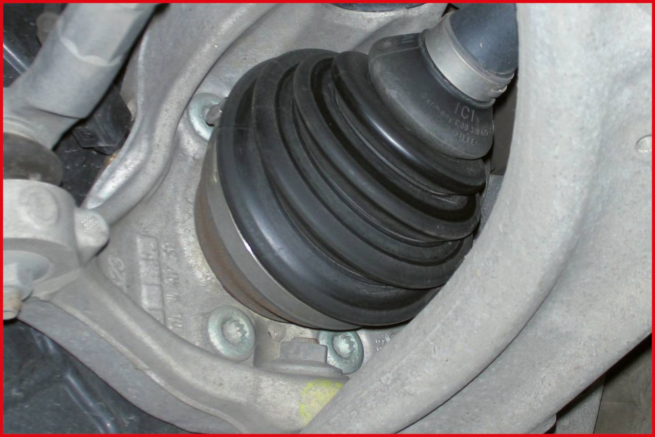 Nahaufnahme eines Antriebsgelenks im Auto, umgeben von Metallkomponenten. Es zeigt die mechanische Verbindung im Fahrzeugsystem.