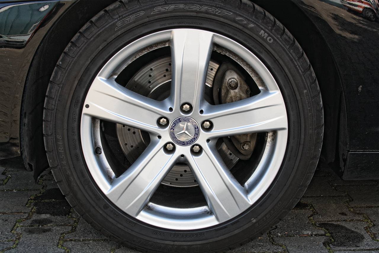 Auto-Reifen mit silberner Felge und sichtbarem Bremsscheiben. Der Reifen hat das Logo eines Sterns in der Mitte der Felge.