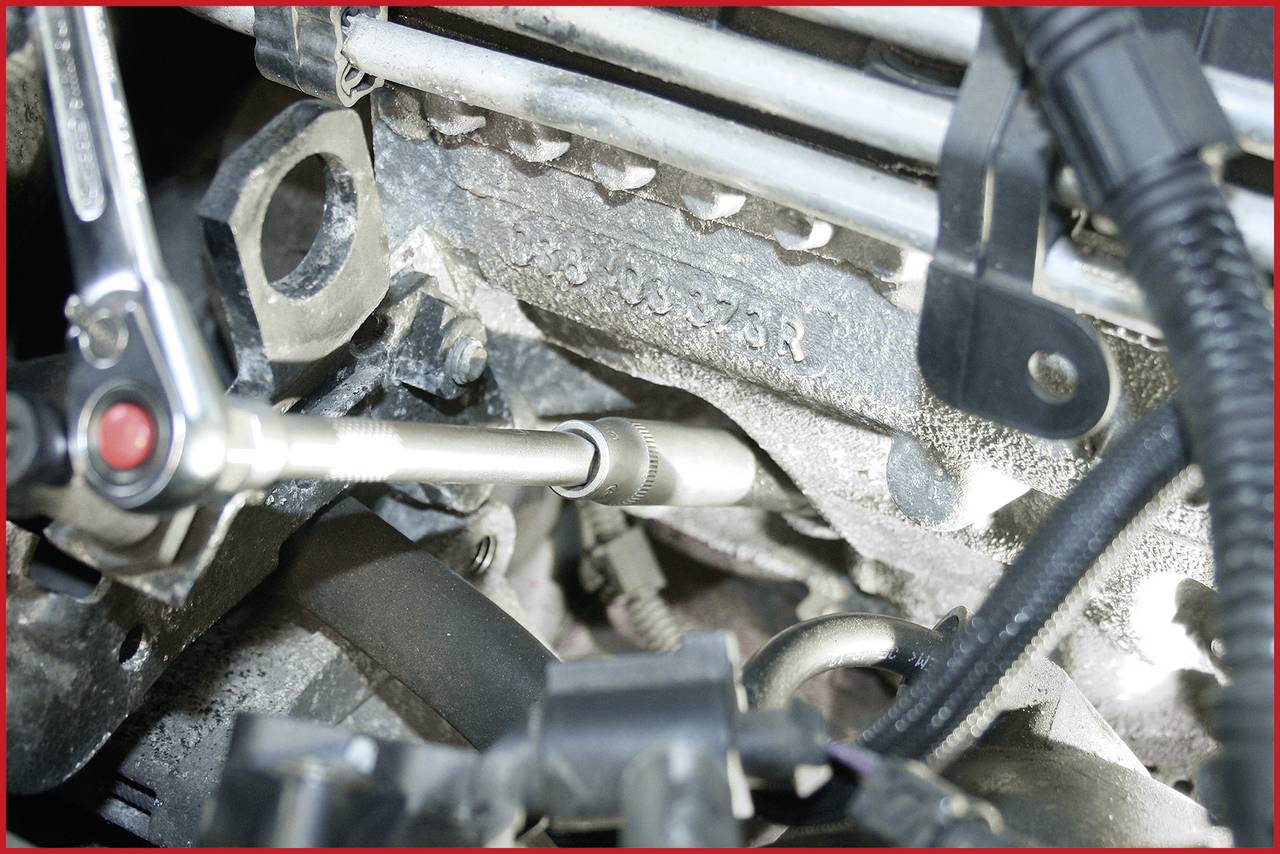 Oberseite eines Motors mit angeschlossenem Werkzeug für Reparatur oder Wartung. Kabel und Motorteile sind sichtbar.