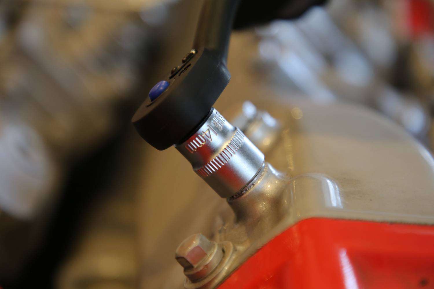 Nahaufnahme eines Schraubenschlüssels, der an einer Metallverbindung arbeitet. Der Hintergrund ist unscharf, Betonung liegt auf dem Schraubvorgang.