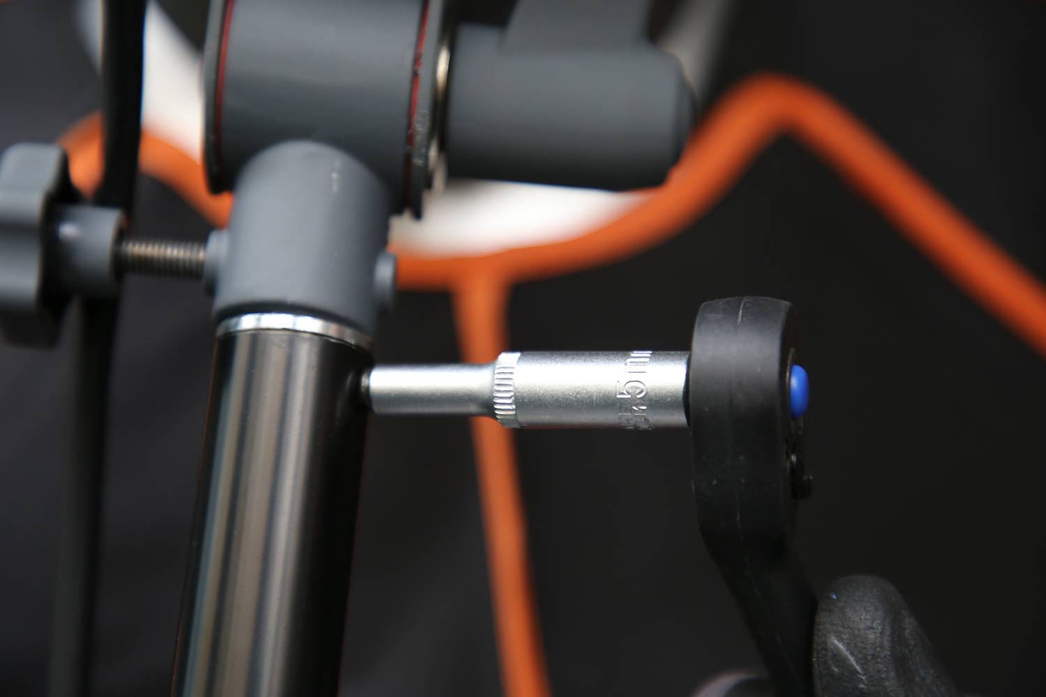 Nahaufnahme eines Fahrradmontages, bei der ein silbernes Werkzeug an einer Schraube eines Fahrrads verwendet wird.