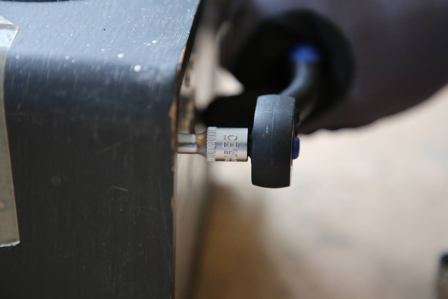 Nahaufnahme eines Messgeräts mit einem Skalenabschnitt von 0 bis 100 Bar. Hand hält den Griff, um das Gerät zu bedienen.