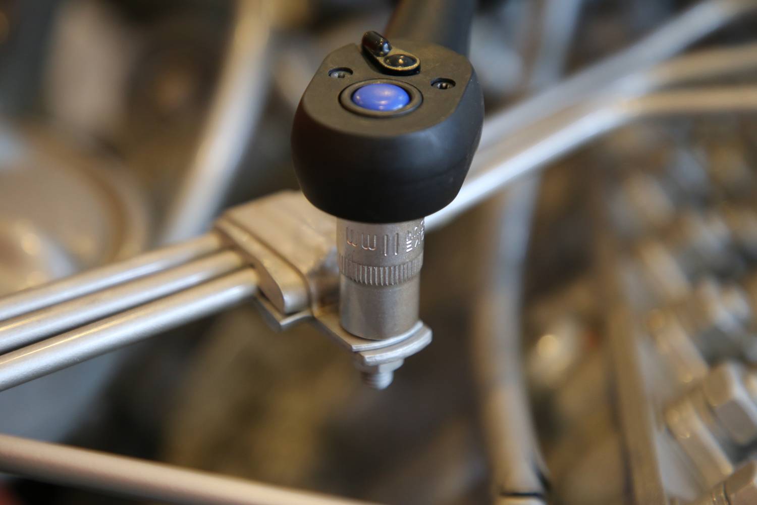 Nahaufnahme eines Drehmomentschlüssels, der an einer Schraube befestigt ist. Das Werkzeug wird in einem technischen Umfeld verwendet.