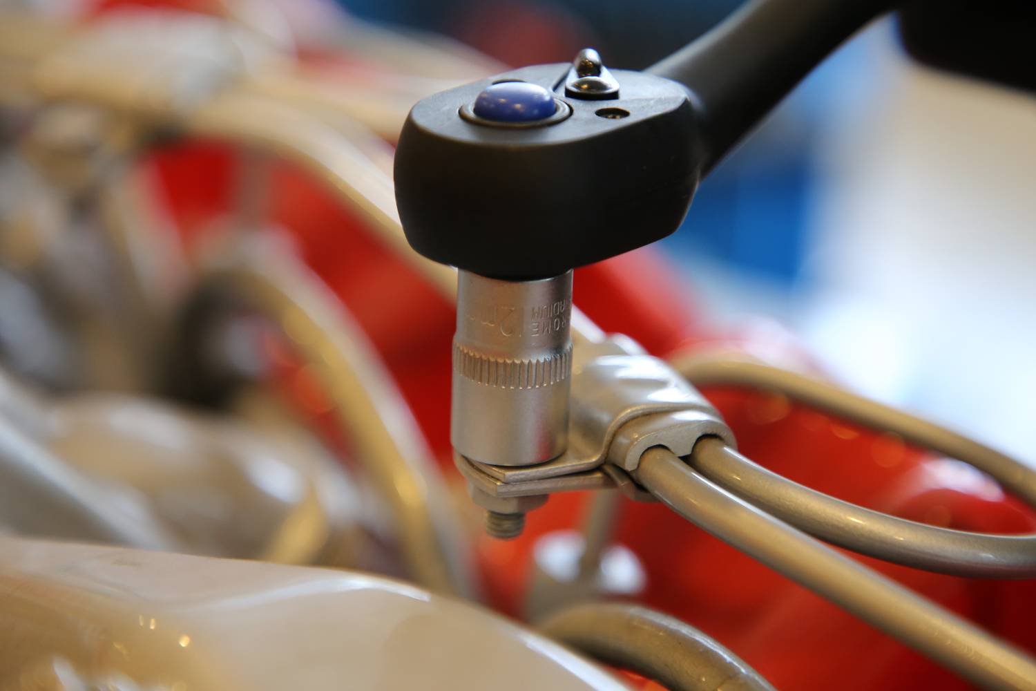 Ein Drehmomentschlüssel zieht eine Schraube an, um Rohre zu befestigen. Nahaufnahme, Fokus auf das Werkzeug und die Schraube.