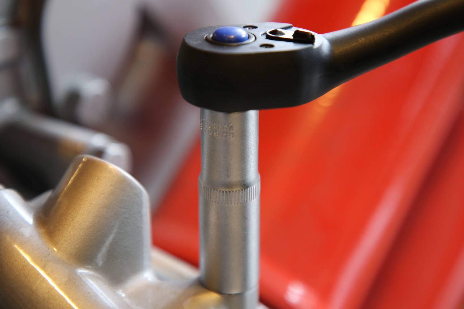 Nahaufnahme eines Drehmomentschlüssels, der an einer Metalloberfläche arbeitet. Das Werkzeug zeigt eine blaue Anzeige.