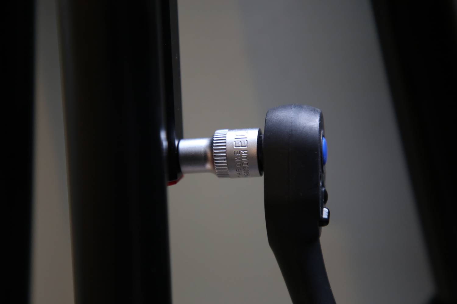 Nahaufnahme eines Schraubenschlüssels, der an einer Metallstange angezogen wird. Zeigt ein Beispiel für den Einsatz von Werkzeug.