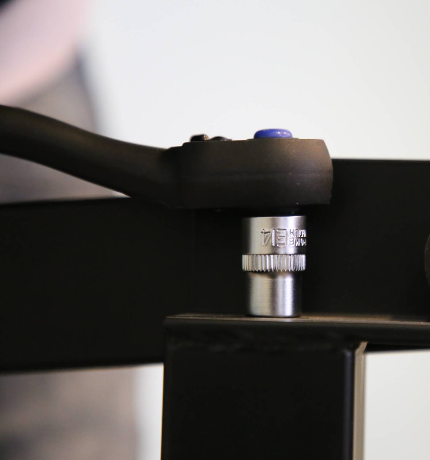 Nahaufnahme eines Metallwerkzeugs mit einem schwarz-griffen Hebel, der an einem schwarzen Metallrahmen angebracht ist.