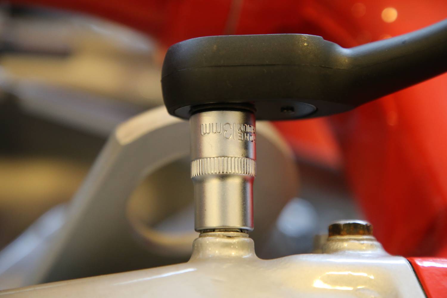 Eine Nahaufnahme eines Schraubenschlüssels, der an einer Schraube arbeitet. Die Szene zeigt eine präzise Handhabung eines Werkzeugs.