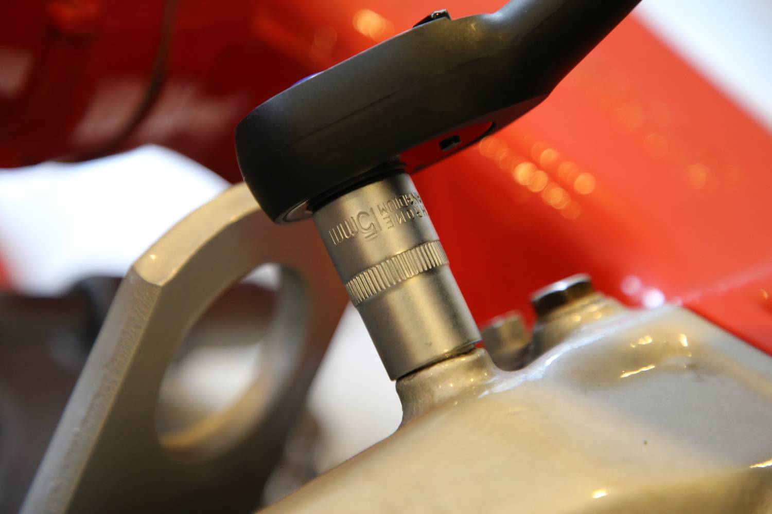 Ein Fahrradschloss ist an einem roten Fahrradrahmen befestigt. Es zeigt eine Nahaufnahme des Schließmechanismus und des Rahmens.