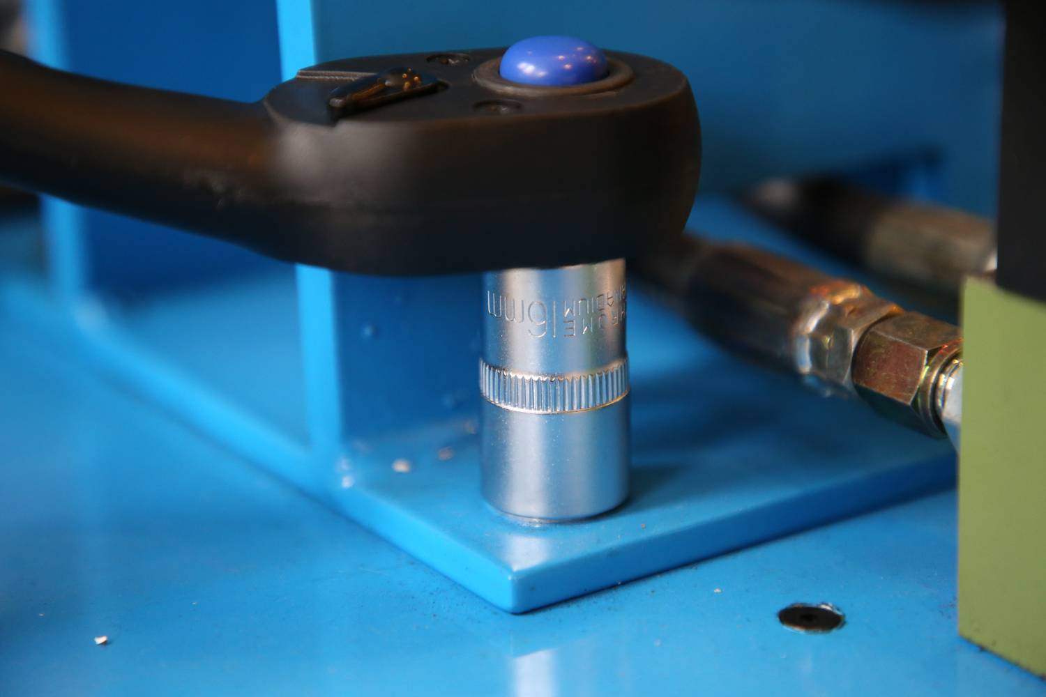 Nahaufnahme eines manuellen Drehmomentschlüssels, der auf eine Mutter aufgesetzt ist. Er wird für präzises Anziehen von Schrauben verwendet.