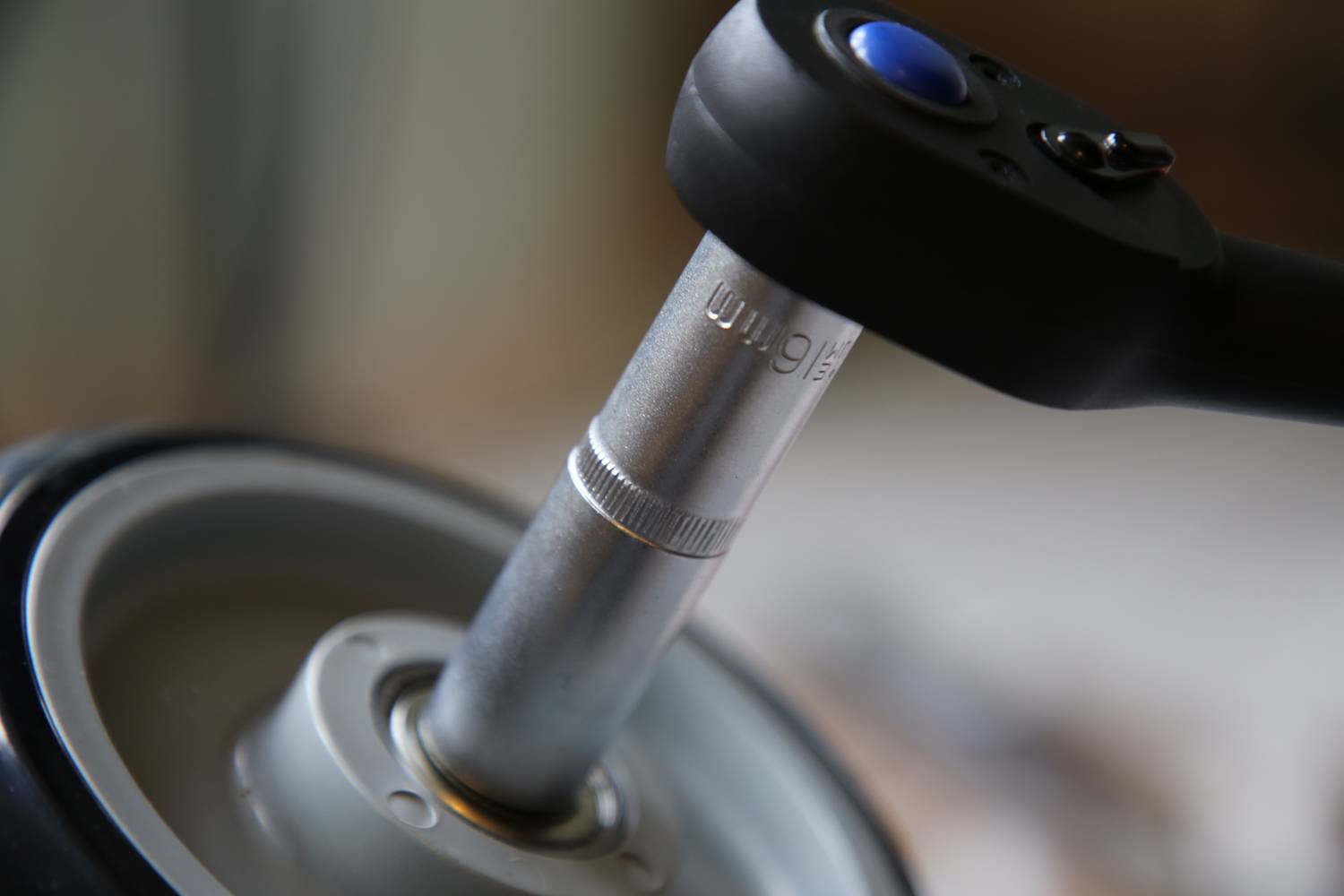 Ein Drehmomentschlüssel zieht eine Schraube fest. Nahaufnahme zeigt das Werkzeug im Einsatz, betont Präzision und Mechanik.