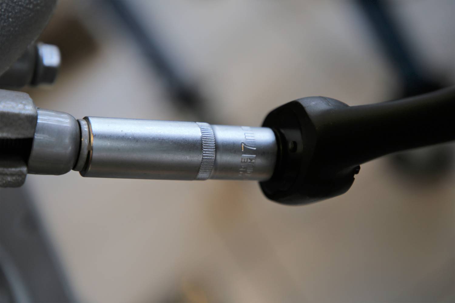 Nahaufnahme eines Drehmomentschlüssels, der an einer Schraube angesetzt wird. Schlüssel zeigt Skala für präzise Einstellung.